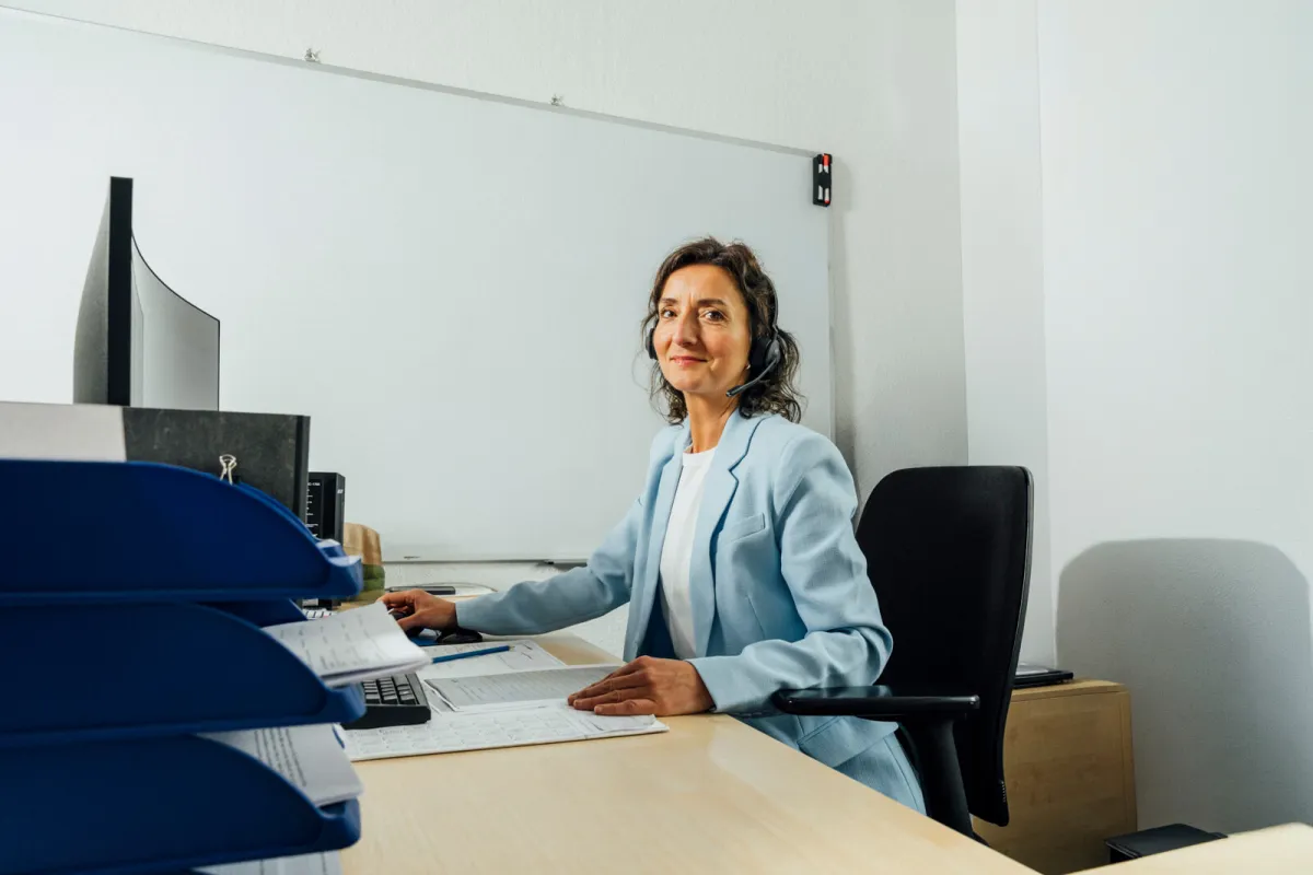 Mitarbeiterin der RG Gebäudereinigung an ihrem Schreibtisch im Büro