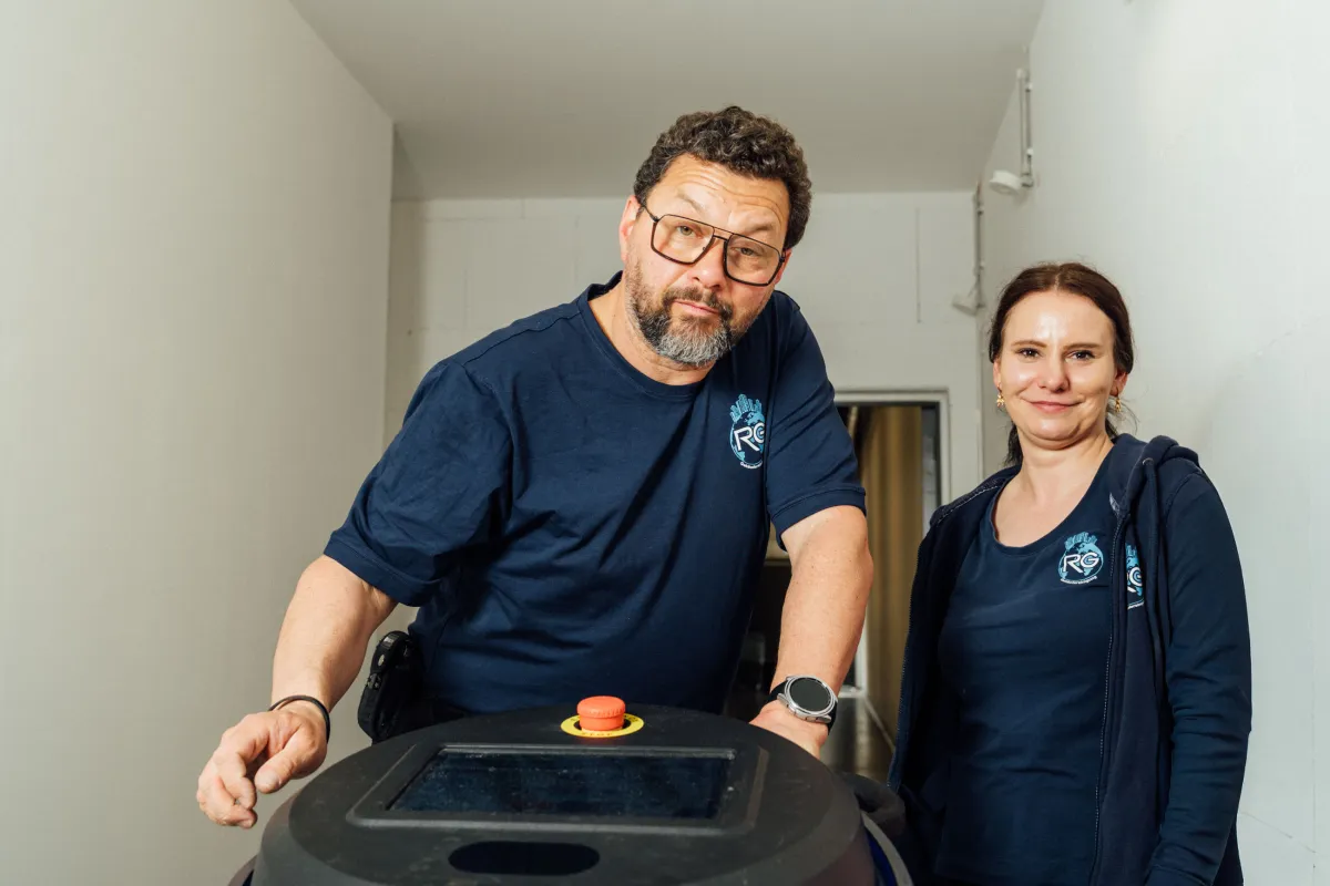 Zwei Mitarbeitende mit einer Reinigungsmaschine in einem Gebäude